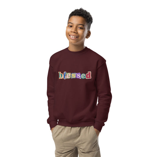 Child wearing a maroon sweatshirt with 'blessed' text, beige shorts, and white shoes on a white background