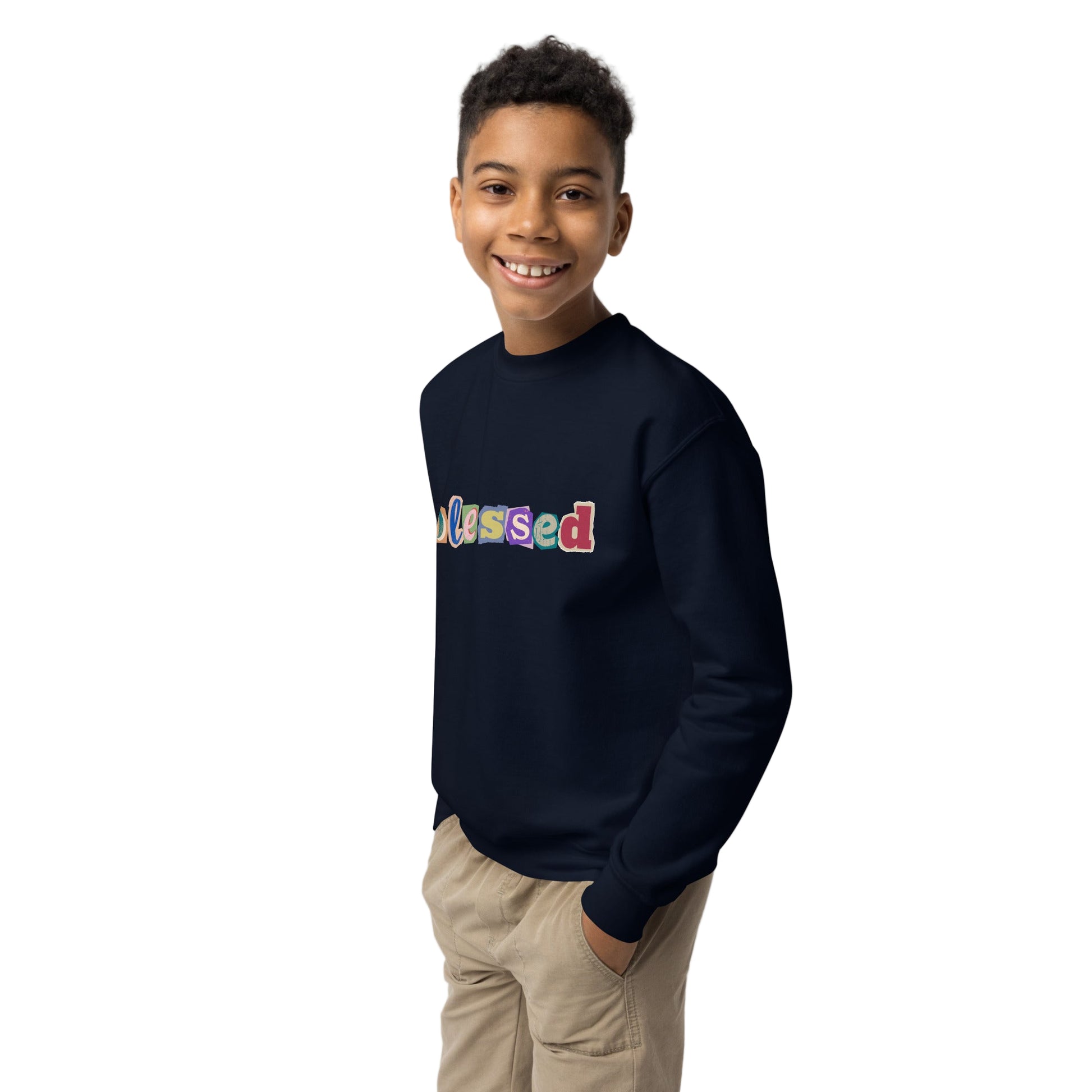Child wearing a navy sweatshirt with 'blessed' in colorful letters on a plain background